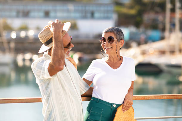Senior Man Holding Straw Hat Hugging Wife At Marina Outdoor Golden Summer. Joyful Senior Man Holding Straw Hat And Hugging Wife, Posing Together At Marina Pier With Yachts And Luxury Sailboats, Laughing And Flirting Enjoying Sunny Day On Vacation Outdoor old rich white guy stock pictures, royalty-free photos & images