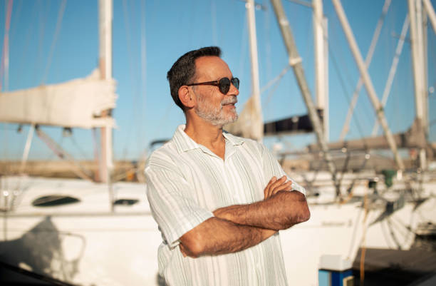 istock Senior man with hands folded amid yachts in marina 1863038059