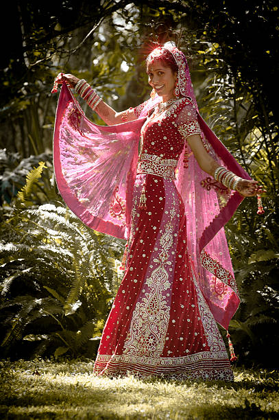 Young indian bride dancing in traditional bridal gown stock photo