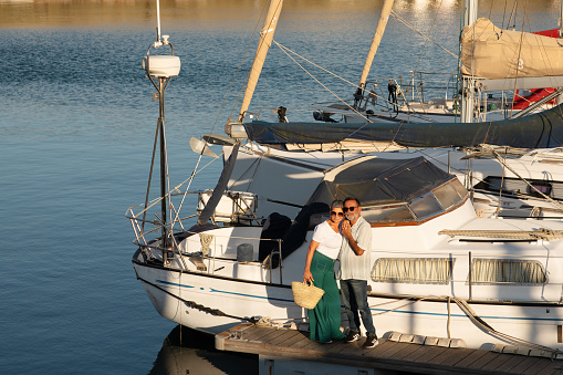 Sailboat Ownership. Senior Family Couple Standing Near Luxury Yacht Embracing Enjoying Holidays Leisure At Seaside Outdoor. Relaxed Husband And Wife Going On Sailing Tour In Summer. Full Length