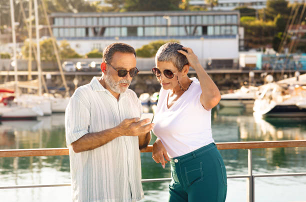 istock Mature Couple Using Smartphone Posing At Sea Port At Seaside 1863038634