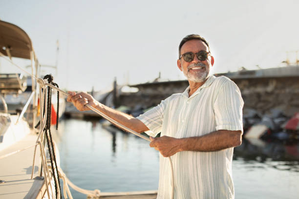 istock Joyful Mature Man Pulling Rope Docking His Sailboat At Marina 1863038645