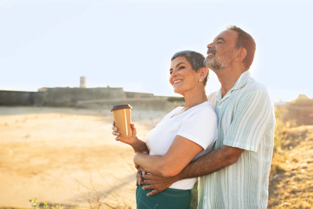 istock Mature Husband Embracing Wife From Back Standing At Coastline Outside 1863038654