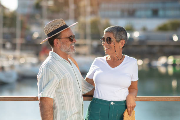istock Elderly spouses sharing summer vacation near vessels at dock outside 1863038664