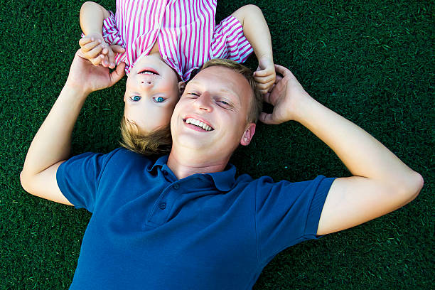 istock happy dad and son lying on the grass 186304769