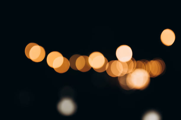 istock Decorative string lights at night time, Defocused Background, night city backdrop, party time with Yellow bokeh balls. 1863057283