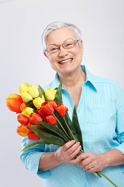 istock Grandmother with flowers smiling 186307308