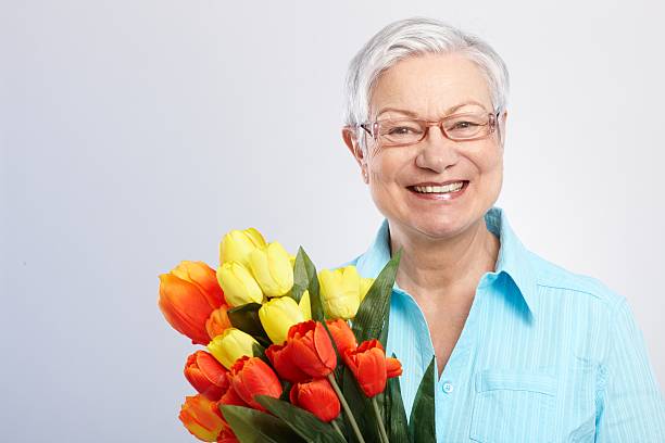 istock Old lady with flowers smiling 186307322