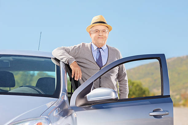 istock Smiling mature gentleman with hat posing next to car 186307721