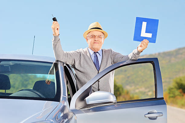 istock Senior man next to car holding L sign and key 186307741