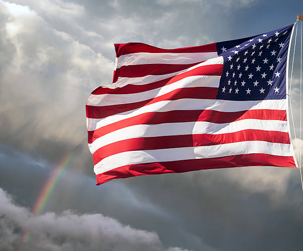 istock American flag against cloudy sky with a rainbow 186307999