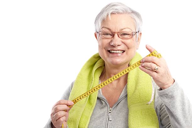 istock Fit old lady with tape measure smiling 186308569