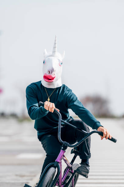 homme avec un masque de licorne faisant du vélo - bmx flatland photos et images de collection