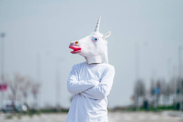 istock Man wearing unicorn mask posing to camera 1863088731