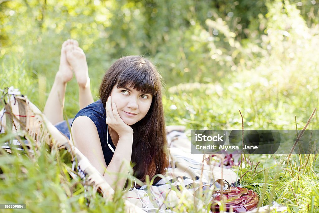 Ritratto di giovane donna ascoltando musica nel parco - Foto stock royalty-free di Abbigliamento casual