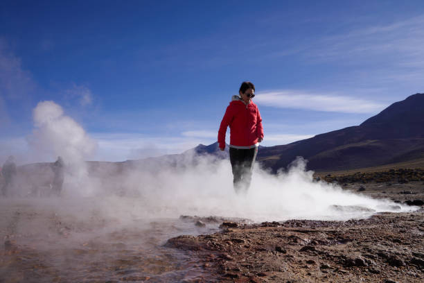 женщина наслаждается видом на гейзер татдио. пустыня атакама. чили. - geyser nature south america scenics стоковые фото и изображения