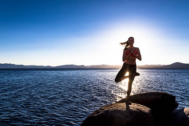 Young woman practices yoga on Lake Tahoe stock photo