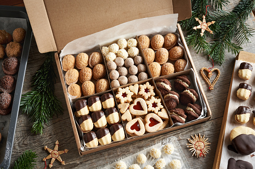 Selection of homemade Christmas cookies in a gift box on a table with fir branches