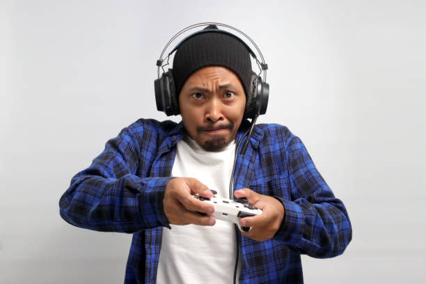 istock Asian gamer is focused while playing games with a gamepad 1863178021