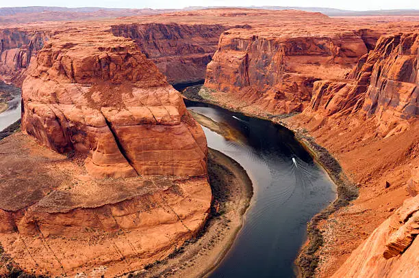 Boats carry travelers far below the ridge in the Colorado River