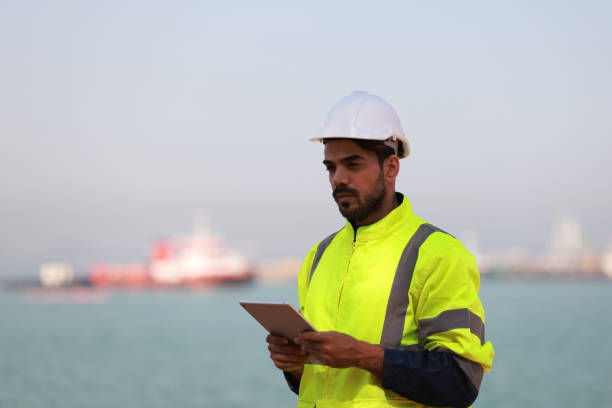 o supervisor logístico do sexo masculino verifica as informações sobre o transporte no porto - industrial ship dock worker engineer harbor - fotografias e filmes do acervo