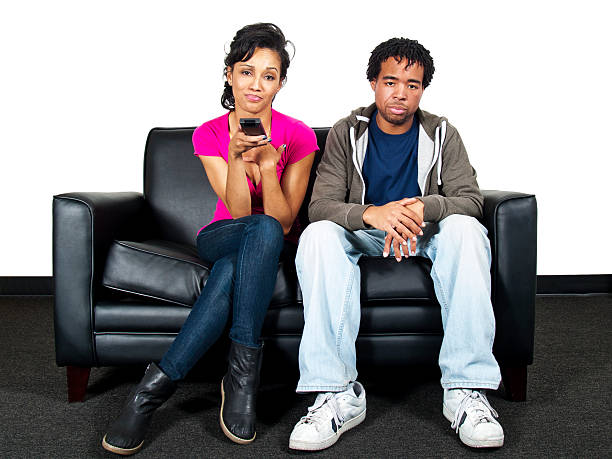 istock Couple on a Couch Channel Surfing on TV with Remote 186320289
