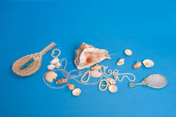 istock Several sea shells, necklaces and mirror scattered on the blue studio floor. 1863213149