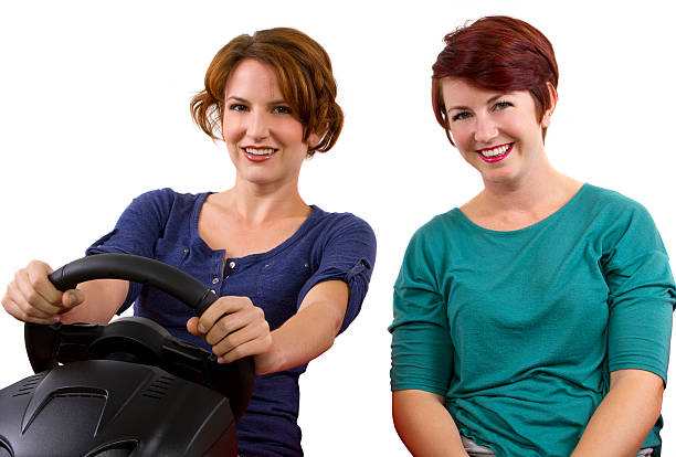 istock Two young female driving on a road trip -white background 186323060