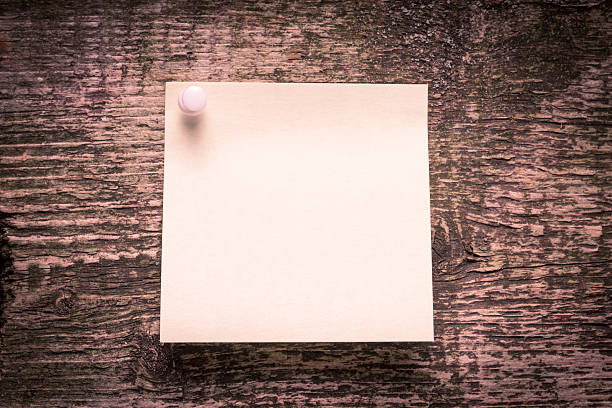 istock Yellow paper sticker on wood weathered background 186323561