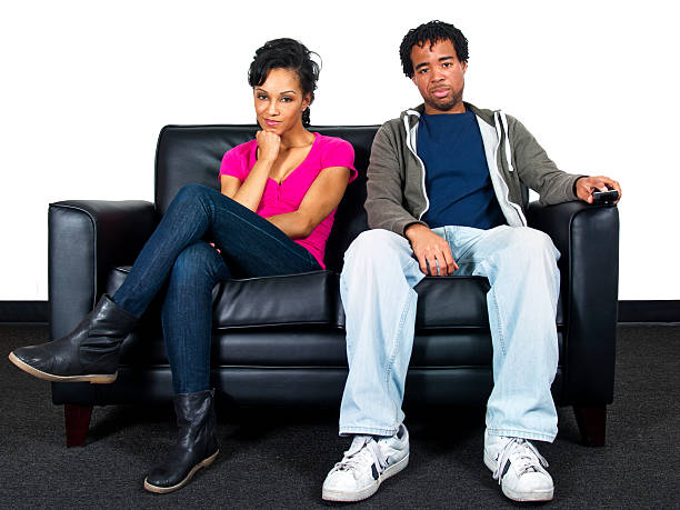 istock Couple on a Couch Channel Surfing on TV with Remote 186323942