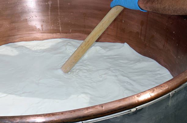 istock worker mixes the milk in a large cauldron 186325566