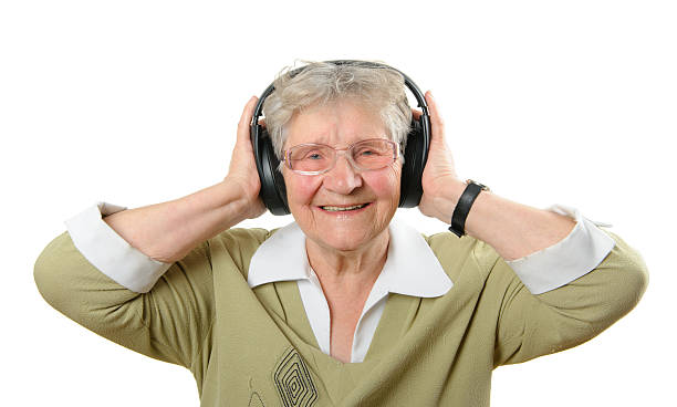 Senior mujer con auriculares aislados en blanco - foto de stock