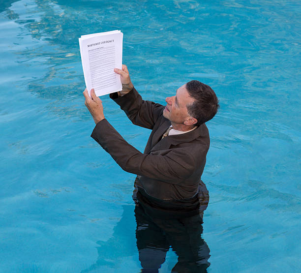 istock Senior man holding mortgage loan document in water 186331701