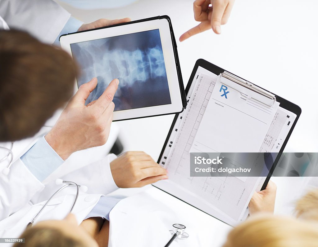 그룹 의사 루킹 at x-레이 on 태블릿 pc - 로열티 프리 건강 진단 스톡 사진
