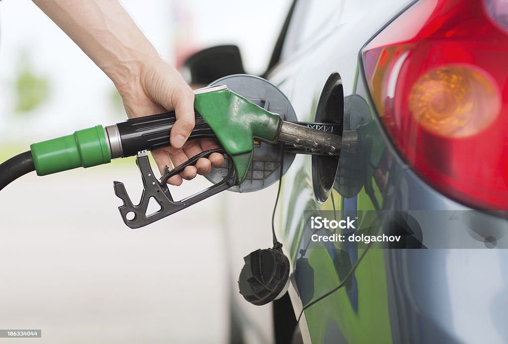 man pumping gasoline fuel in car at gas station transportation and ownership concept - man pumping gasoline fuel in car at gas station Adult Stock Photo