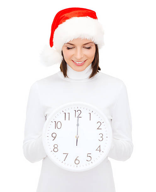 istock woman in santa helper hat with clock showing 12 186335475