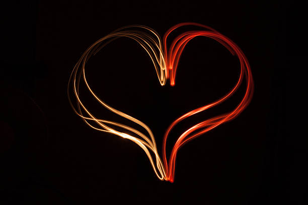 Light painting heart shape over black background