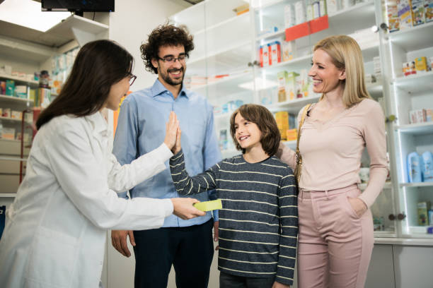 istock Boy throwing a high-five to a pharmacist during a purchase with his parents 1863388251