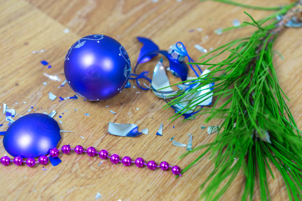 kuvapankkikuvat ja rojaltivapaat kuvat aiheesta rikkoutuneet violetit lelut makaavat lattialla joulukuusen oksalla lasipallon sirpaleet - crash helmet