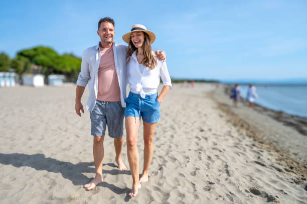 istock Couple in love walking on beach barefoot 1863398701