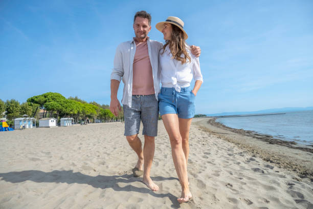istock Couple in love walking on beach barefoot 1863398702