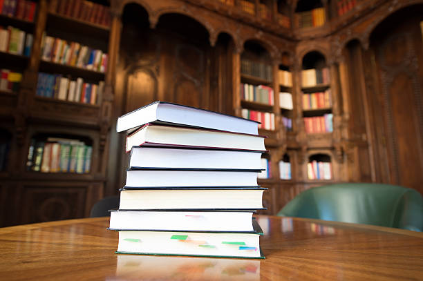 istock Stacked books with library in the background 186341613
