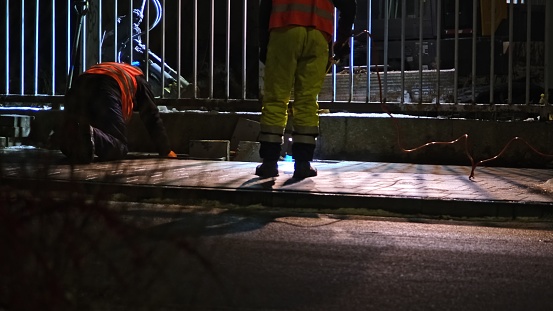 Nighttime Roadworks Construction Site Worker Paver Heating Gas Torch To Heat Pedestrian Sidewalk Flagstones