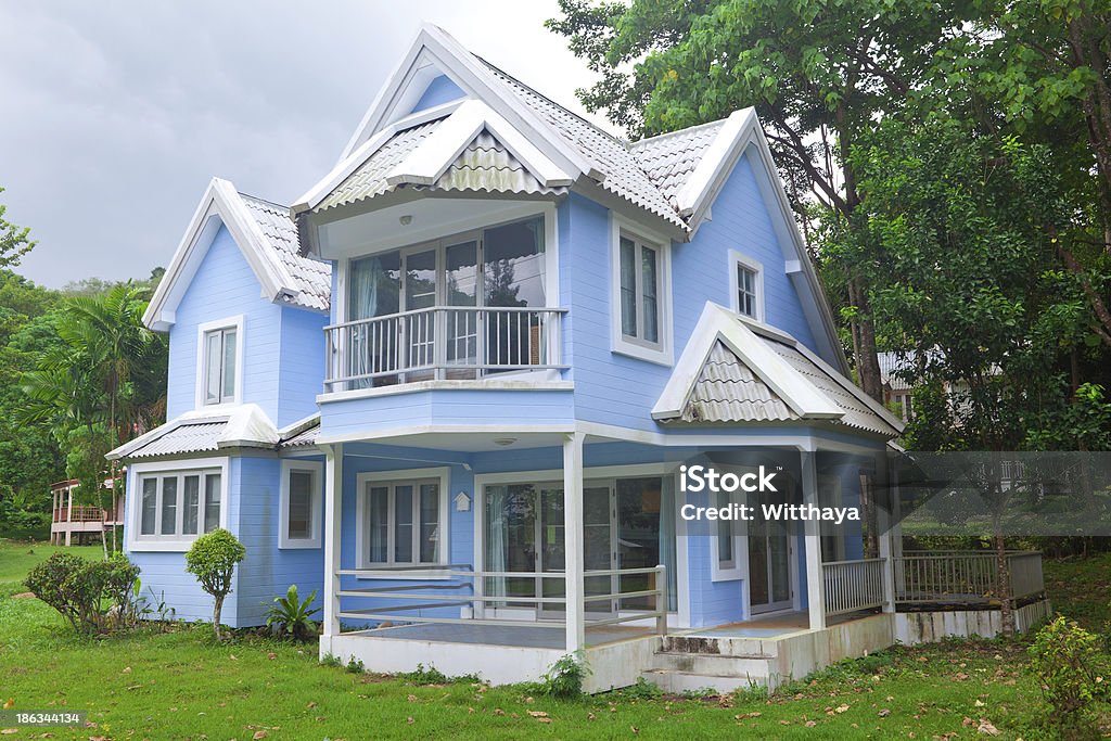 blue house in forest Beautiful blue house and big tree in forest Architecture Stock Photo