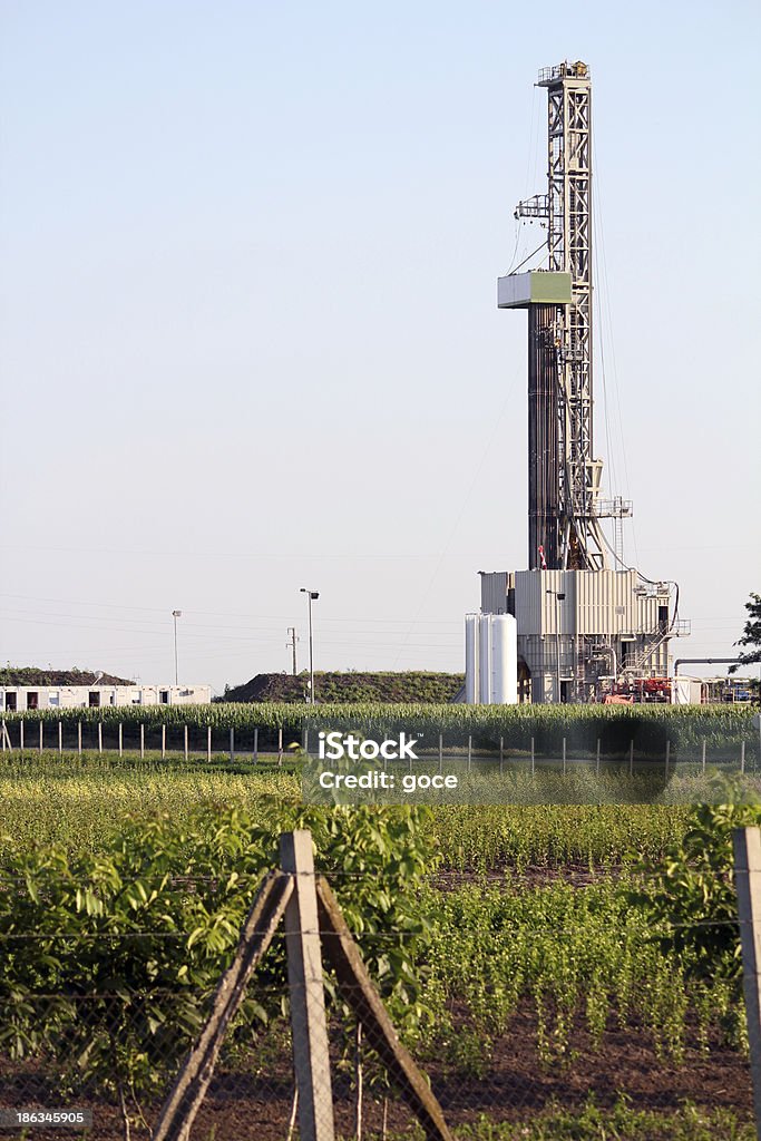 Giacimento petrolifero con terra di perforazione rig - Foto stock royalty-free di Acciaio