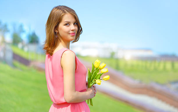istock Smiling girl with yellow tulips 186346896