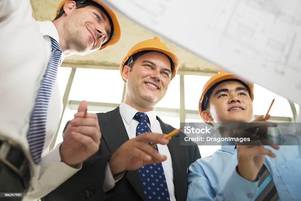 Project analyzing Angle view of engineers analyzing the project together on the foreground Adult Stock Photo