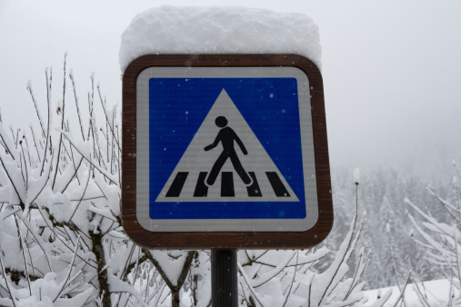 Pedestrian road crossing sign buried in deep snow.