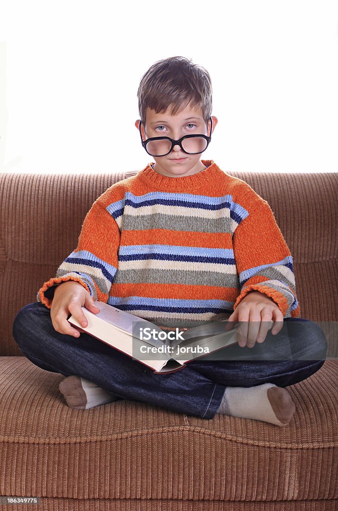 Ребенок сидит на диване с книги - Стоковые фото Б�иблиография роялти-фри