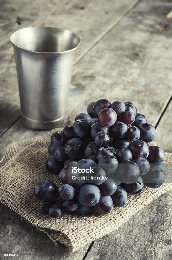 Uvas en la antigua mesa de madera. - Foto de stock de Agricultura libre de derechos